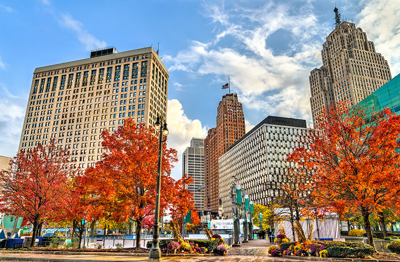 Autumn leaves on the trees in Campus Martius Park with a clear blue sky above