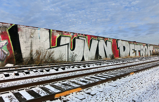 a wall by train tracks spraypainted with Luvn Detroit