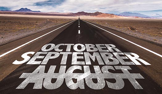 a road stretches into the distance leading to distant mountains - painted on the road are the words august, september, october, and august has a line painted through it