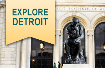 frontal view of The Thinker statue outside the Detroit Institute of Arts and includes a yellow banner with the words Explore Detroit