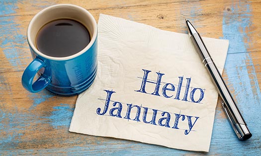 welcome january written on a piece of paper next to a fancy pen and a cup of hot coffee